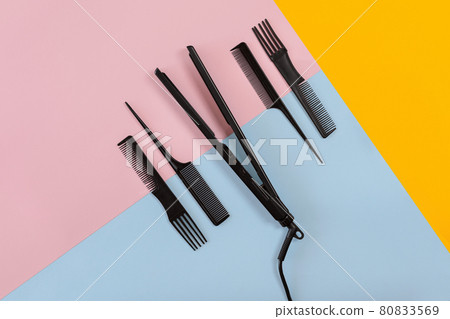 Various hair styling devices on the color blue, yellow, pink paper background, top view Various hair styling devices on the color blue, yellow, pink paper background, top view 80833569