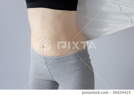 Close-up of a woman's stomach. Train your abdominal muscles and correct pelvic distortion 80834425