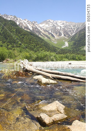 Shinshu Kamikochi, the Azusa River that flows purely surrounded by the fresh green of spring and the Hotaka mountain range that can be seen in the background 80834735