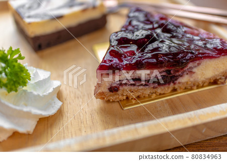 blueberry cheesecake served on wooden plate. 80834963