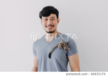 Happy man with his shy Sugar Glider climbing on his body. Happy man with his shy Sugar Glider climbing on his body. 80835179