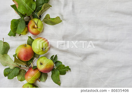 Autumn background of small apple and leaves on biege linen textile background. Empty space for text. Top view. Autumn background of small apple and leaves on biege linen textile background. Empty space for text. Top view. 80835406