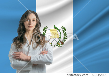 Medicine in Guatemala. Happy beautiful female doctor in medical coat standing with crossed arms against the background of the flag of Guatemala 80835466