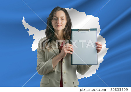 Study in Antarctica. Beautiful woman holding a sheet of paper in her hands. Girl on the background of the flag of Antarctica Study in Antarctica. Beautiful woman holding a sheet of paper in her hands. Girl on the background of the flag of Antarctica 80835509