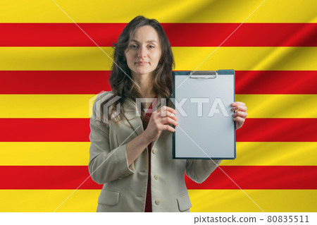 Study in Catalonia. Beautiful woman holding a sheet of paper in her hands. Girl on the background of the flag of Catalonia Study in Catalonia. Beautiful woman holding a sheet of paper in her hands. Girl on the background of the flag of Catalonia 80835511