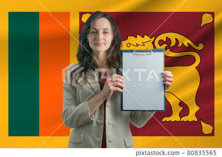 Study in Sri Lanka. Beautiful woman holding a sheet of paper in her hands. Girl on the background of the flag of Sri Lanka Study in Sri Lanka. Beautiful woman holding a sheet of paper in her hands. Girl on the background of the flag of Sri Lanka 80835565