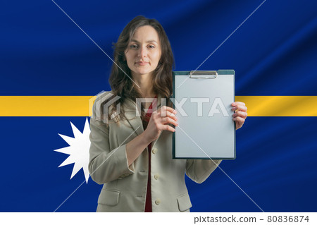 Study in Nauru. Beautiful woman holding a sheet of paper in her hands. Girl on the background of the flag of Nauru 80836874