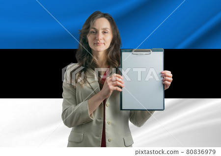 Study in Estonia Beautiful woman holding a sheet of paper in her hands. Girl on the background of the flag of Estonia Study in Estonia Beautiful woman holding a sheet of paper in her hands. Girl on the background of the flag of Estonia 80836979