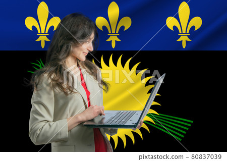 Freelance in Guadeloupe. Beautiful young woman freelancer uses laptop computer against the background of the flag of Guadeloupe Freelance in Guadeloupe. Beautiful young woman freelancer uses laptop computer against the background of the flag of Guadeloupe 80837039