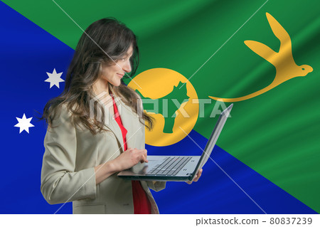 Freelance in Christmas Island. Beautiful young woman freelancer uses laptop computer against the background of the flag of Christmas Island Freelance in Christmas Island. Beautiful young woman freelancer uses laptop computer against the background of the flag of Christmas Island 80837239