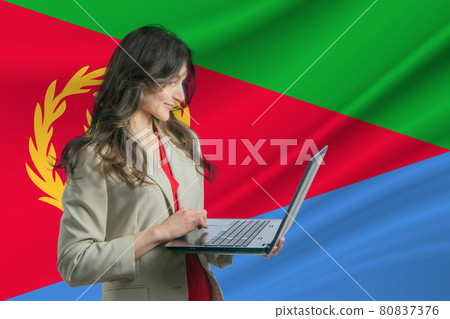 Freelance in Eritrea Beautiful young woman freelancer uses laptop computer against the background of the flag of Eritrea Freelance in Eritrea Beautiful young woman freelancer uses laptop computer against the background of the flag of Eritrea 80837376