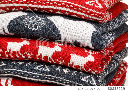 Stack of folded knitted Christmas turtleneck sweaters closeup Stack of folded knitted Christmas turtleneck sweaters closeup 80838219