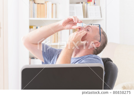 Man applying eye drops Man applying eye drops 80838275