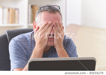 Tired freelancer man rubbing his eye Tired freelancer man rubbing his eye 80838276