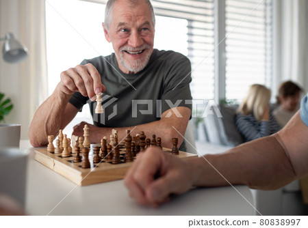 Group of senior friends playing board games indoors, party and social gathering concept. Group of senior friends playing board games indoors, party and social gathering concept. 80838997