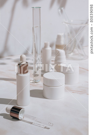 Cosmetic skin care products on white background with plant shadows 80839098