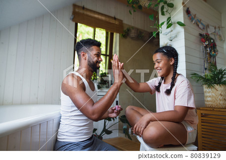 Happy young man with small sister indoors at home, giving high five. Happy young man with small sister indoors at home, giving high five. 80839129