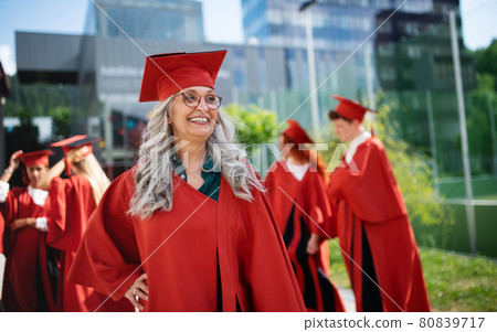 Portrait of cheerful senior woman student outdoors, graduation and third age university concept. Portrait of cheerful senior woman student outdoors, graduation and third age university concept. 80839717