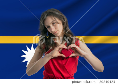 Love Nauru. A girl holds a heart on her chest in her hands against the background of the flag of Nauru. The concept of patriotism Love Nauru. A girl holds a heart on her chest in her hands against the background of the flag of Nauru. The concept of patriotism 80840423