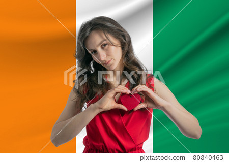 Love C te d'Ivoire A girl holds a heart on her chest in her hands against the background of the flag of C te d'Ivoire The concept of patriotism 80840463