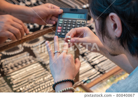 Guy tries on silver rings in india market Guy tries on silver rings in india market 80840867