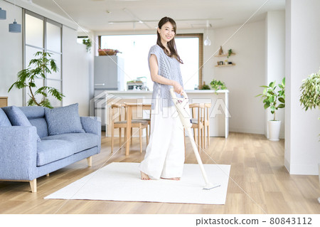 Young woman vacuuming in the living room Young woman vacuuming in the living room 80843112