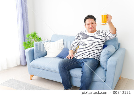Middle-aged man drinking beer at home Middle-aged man drinking beer at home 80843151