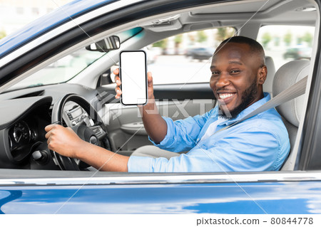 Happy black driver using showing smartphone with white empty screen Happy black driver using showing smartphone with white empty screen 80844778