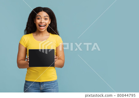 Overjoyed african american lady showing digitral tablet with black screen, demonstrating space for mockup design Overjoyed african american lady showing digitral tablet with black screen, demonstrating space for mockup design 80844795
