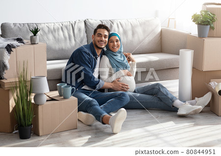 Happy pregnant middle-eastern couple posing at new house Happy pregnant middle-eastern couple posing at new house 80844951