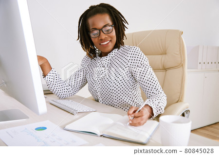 Businesswoman in Glasses Taking Notes in Planner Businesswoman in Glasses Taking Notes in Planner 80845028