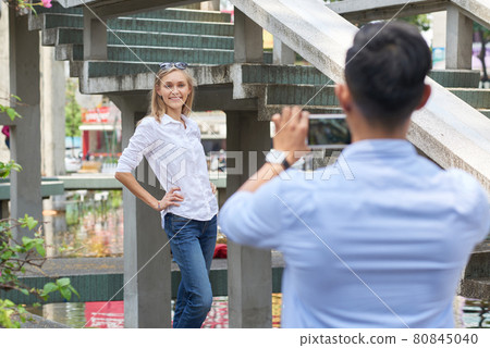 Woman Posing for Photo in Front of Boyfriend Woman Posing for Photo in Front of Boyfriend 80845040