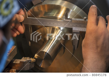 The machine operator use Vernier caliper measure brass material parts . The machine operator use Vernier caliper measure brass material parts . 80845178