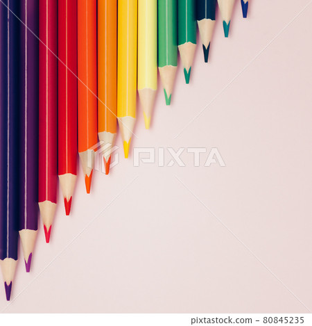 Colored pointed pencils lie on a pink background with space for copying. School supplies or school Colored pointed pencils lie on a pink background with space for copying. School supplies or school 80845235
