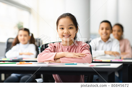 Portrait of small asian girl sitting at desk in classroom Portrait of small asian girl sitting at desk in classroom 80845672
