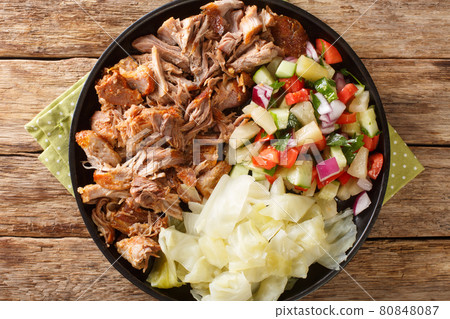 Hawaiian Slow cooked Kalua pork served with cabbage and salad close-up on a plate. horizontall top view Hawaiian Slow cooked Kalua pork served with cabbage and salad close-up on a plate. horizontall top view 80848087