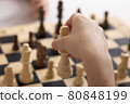 Girls hand moving a king chess, close up 80848199