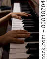 Young girl is clipping piano at home. Dark key photo 80848204