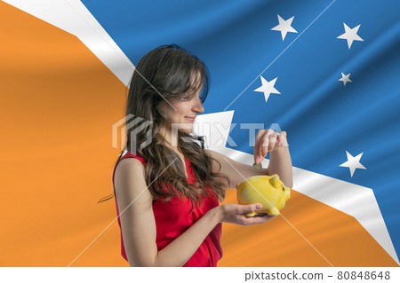 Economy in Argentine Antarctica. Accumulating and saving money in Argentine Antarctica. Woman putting money coin in piggy bank for saving money and plan finance Economy in Argentine Antarctica. Accumulating and saving money in Argentine Antarctica. Woman putting money coin in piggy bank for saving money and plan finance 80848648