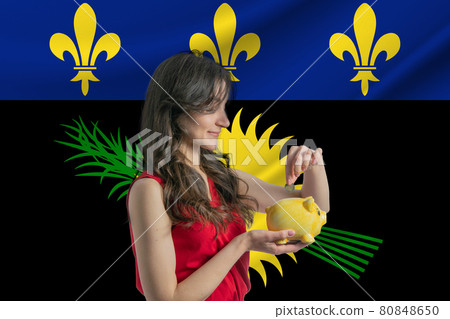 Economy in Guadeloupe. Accumulating and saving money in Guadeloupe. Woman putting money coin in piggy bank for saving money and plan finance Economy in Guadeloupe. Accumulating and saving money in Guadeloupe. Woman putting money coin in piggy bank for saving money and plan finance 80848650