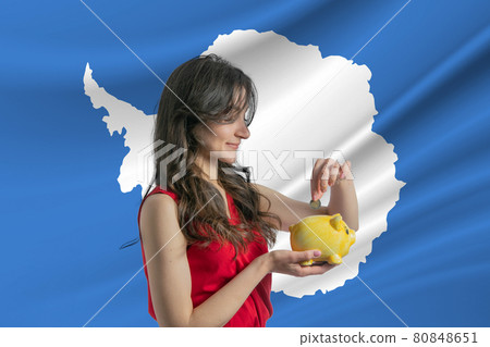 Economy in Antarctica. Accumulating and saving money in Antarctica. Woman putting money coin in piggy bank for saving money and plan finance Economy in Antarctica. Accumulating and saving money in Antarctica. Woman putting money coin in piggy bank for saving money and plan finance 80848651