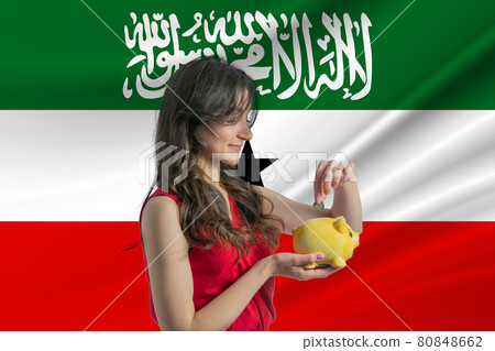 Economy in Somaliland. Accumulating and saving money in Somaliland. Woman putting money coin in piggy bank for saving money and plan finance Economy in Somaliland. Accumulating and saving money in Somaliland. Woman putting money coin in piggy bank for saving money and plan finance 80848662