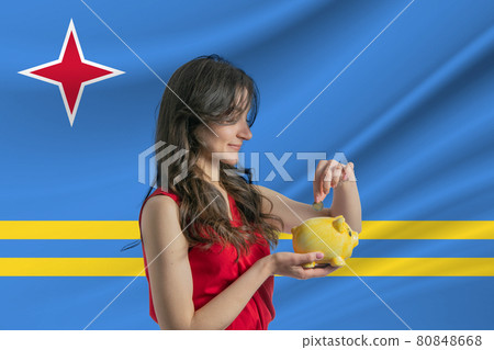 Economy in Aruba. Accumulating and saving money in Aruba. Woman putting money coin in piggy bank for saving money and plan finance Economy in Aruba. Accumulating and saving money in Aruba. Woman putting money coin in piggy bank for saving money and plan finance 80848668