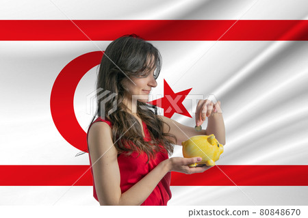 Economy in Turkish Republic of Northern Cyprus. Accumulating and saving money in Turkish Republic of Northern Cyprus. Woman putting money coin in piggy bank for saving money and plan finance Economy in Turkish Republic of Northern Cyprus. Accumulating and saving money in Turkish Republic of Northern Cyprus. Woman putting money coin in piggy bank for saving money and plan finance 80848670