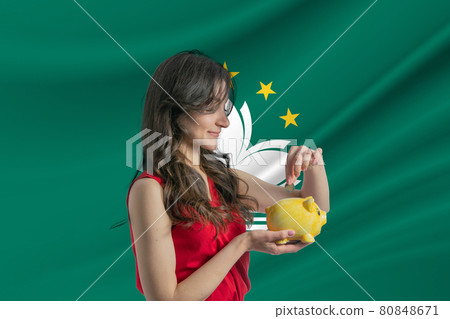 Economy in Macau. Accumulating and saving money in Macau. Woman putting money coin in piggy bank for saving money and plan finance Economy in Macau. Accumulating and saving money in Macau. Woman putting money coin in piggy bank for saving money and plan finance 80848671