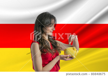 Economy in South Ossetia. Accumulating and saving money in South Ossetia. Woman putting money coin in piggy bank for saving money and plan finance Economy in South Ossetia. Accumulating and saving money in South Ossetia. Woman putting money coin in piggy bank for saving money and plan finance 80848675