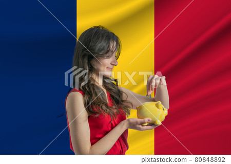 Economy in Chad. Accumulating and saving money in Chad. Woman putting money coin in piggy bank for saving money and plan finance Economy in Chad. Accumulating and saving money in Chad. Woman putting money coin in piggy bank for saving money and plan finance 80848892