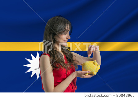 Economy in Nauru. Accumulating and saving money in Nauru. Woman putting money coin in piggy bank for saving money and plan finance 80848963