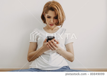 Woman resting and relax in the room with her smartphone in hand. Woman resting and relax in the room with her smartphone in hand. 80849099