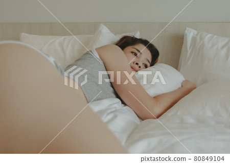 Attractive woman lay on the bed feeling relax and cosy in the morning Attractive woman lay on the bed feeling relax and cosy in the morning 80849104